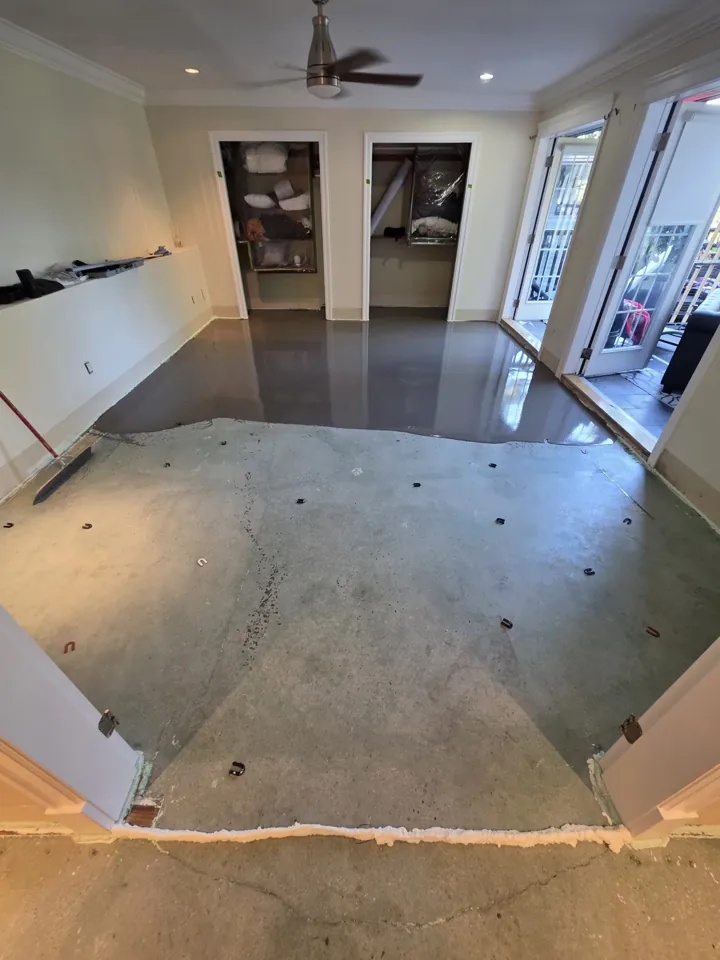 Leveling compound spreading across the primed Westport bedroom subfloor