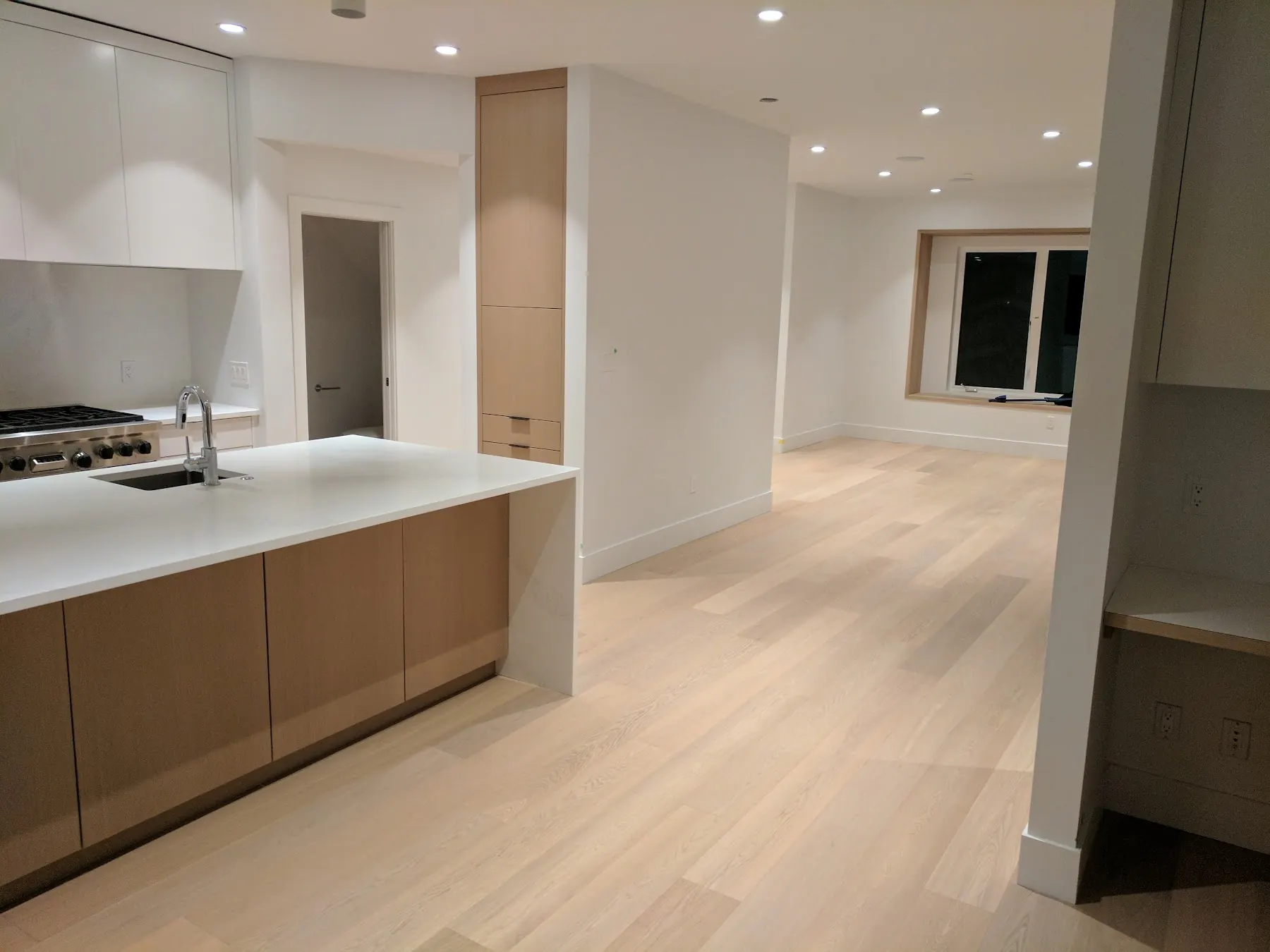 A continuous floor through an open kitchen and living space.