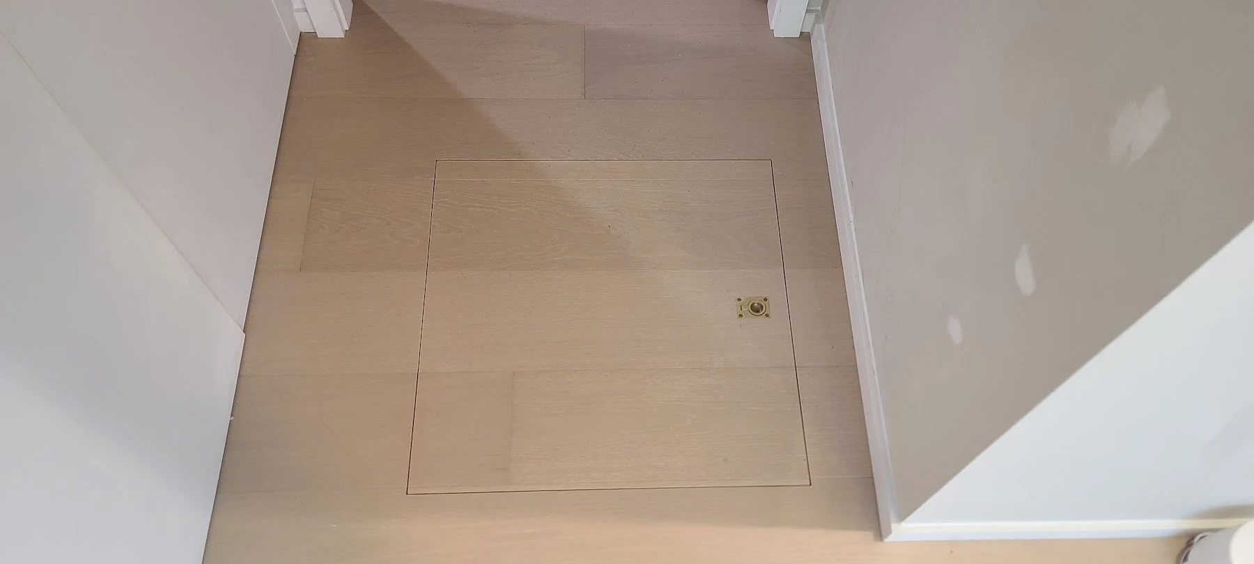 A flush hatch fitted into the oak floor.