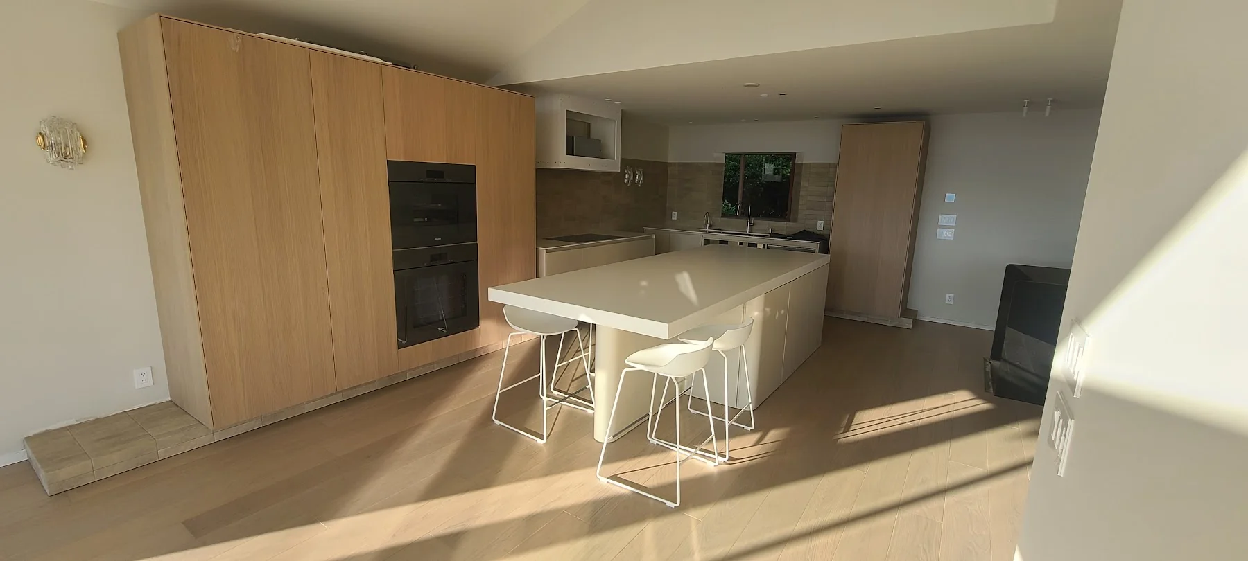 Sunlight across the oak floor around the kitchen island.
