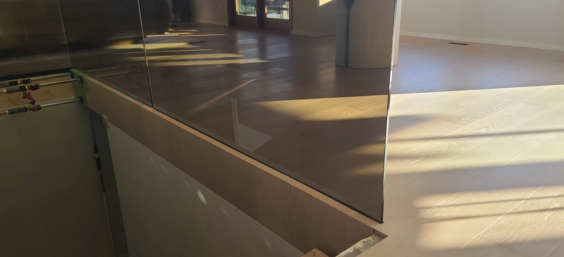 The oak waterfall edge continues beneath the glass.