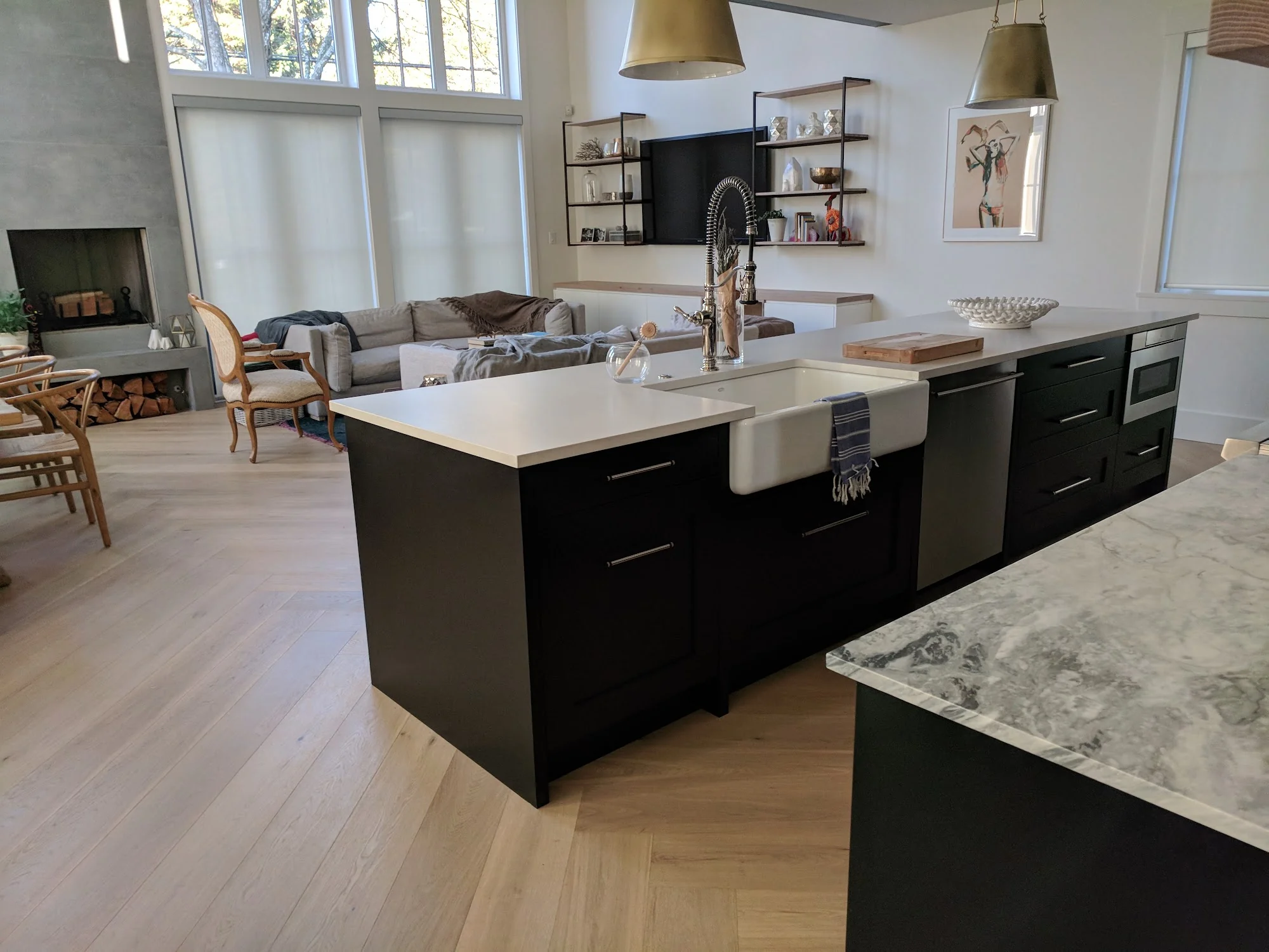 Patterned hardwood flowing around a black kitchen island