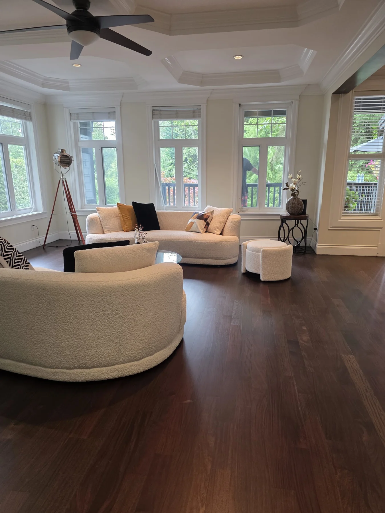 Refinished hardwood through the sunlit sitting room.