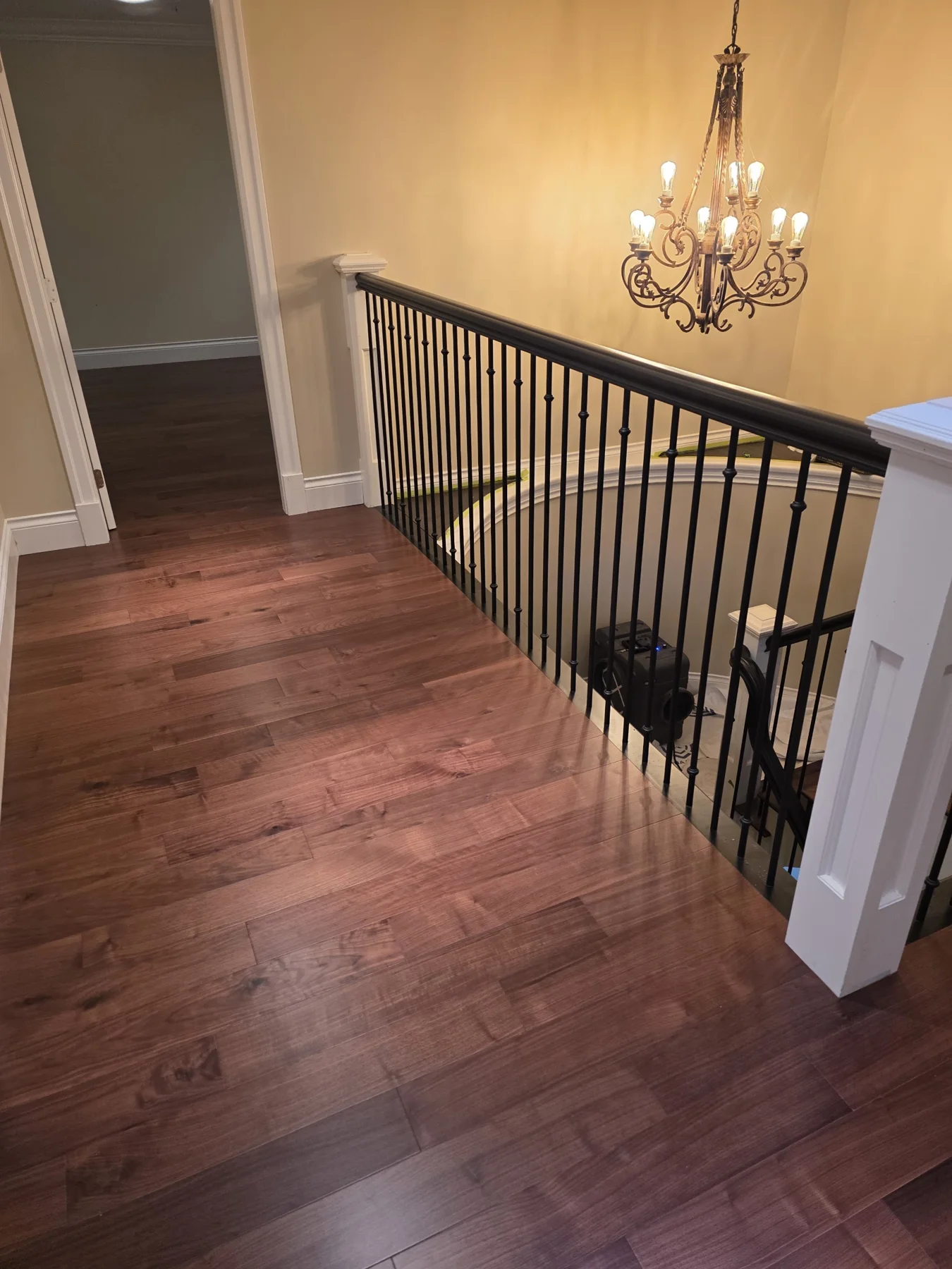 The restained and reinstalled handrail beside the new hardwood.