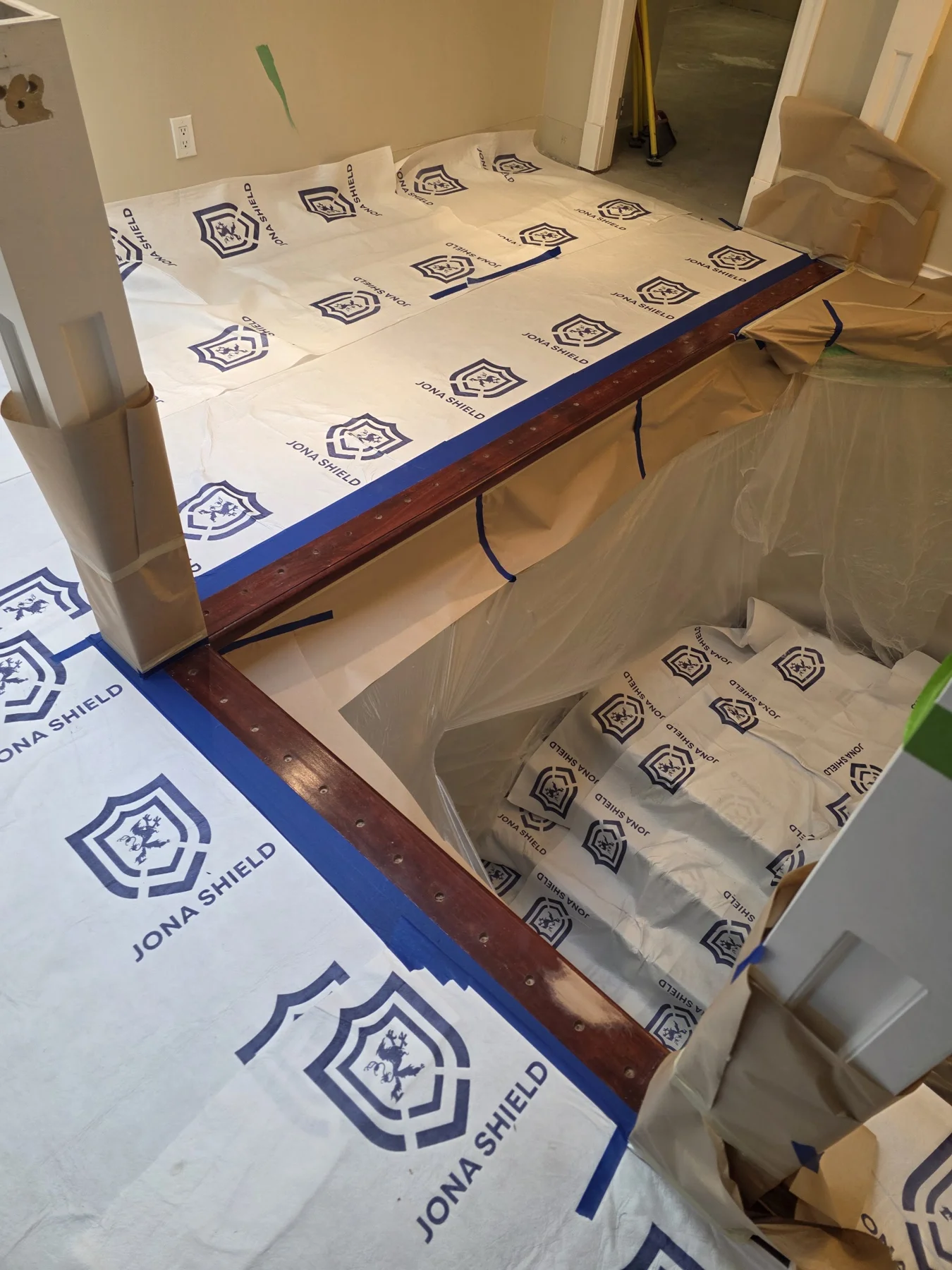 The stair opening and surrounding surfaces masked off for nosing staining.